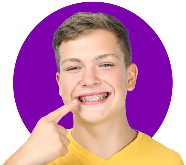Smiling teenage boy pointing at his metal braces at Family Braces Calgary